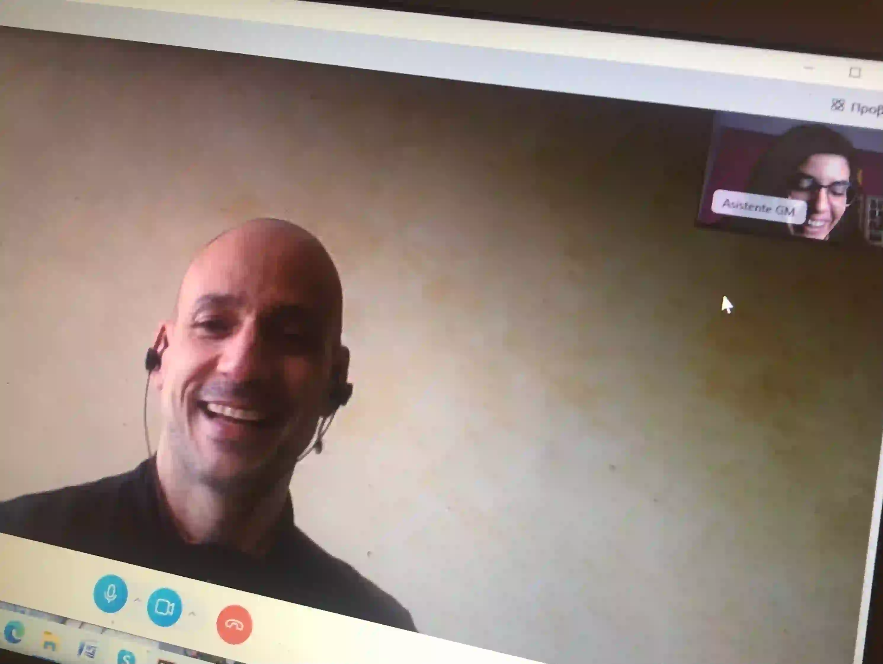A laughing student in earphones on a Skype Greek lesson