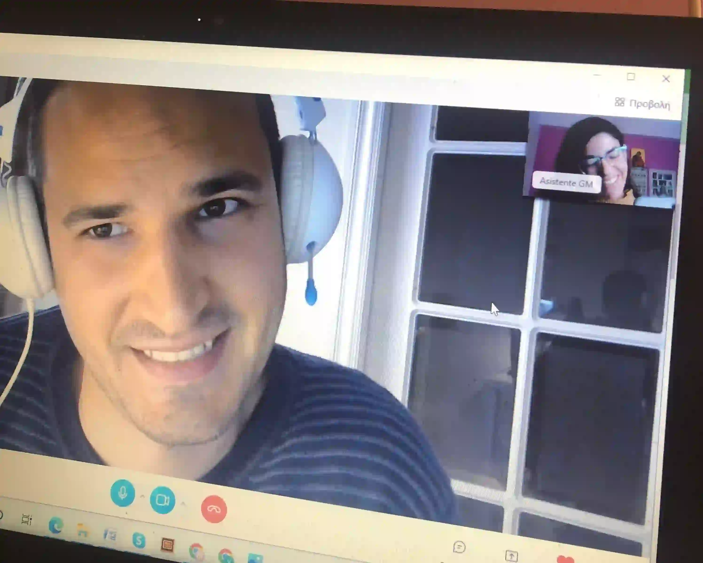A smiling student in headphones on a Skype Greek lesson